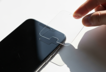 Smartphone with tempered glass screen protector being applied (illustrative)